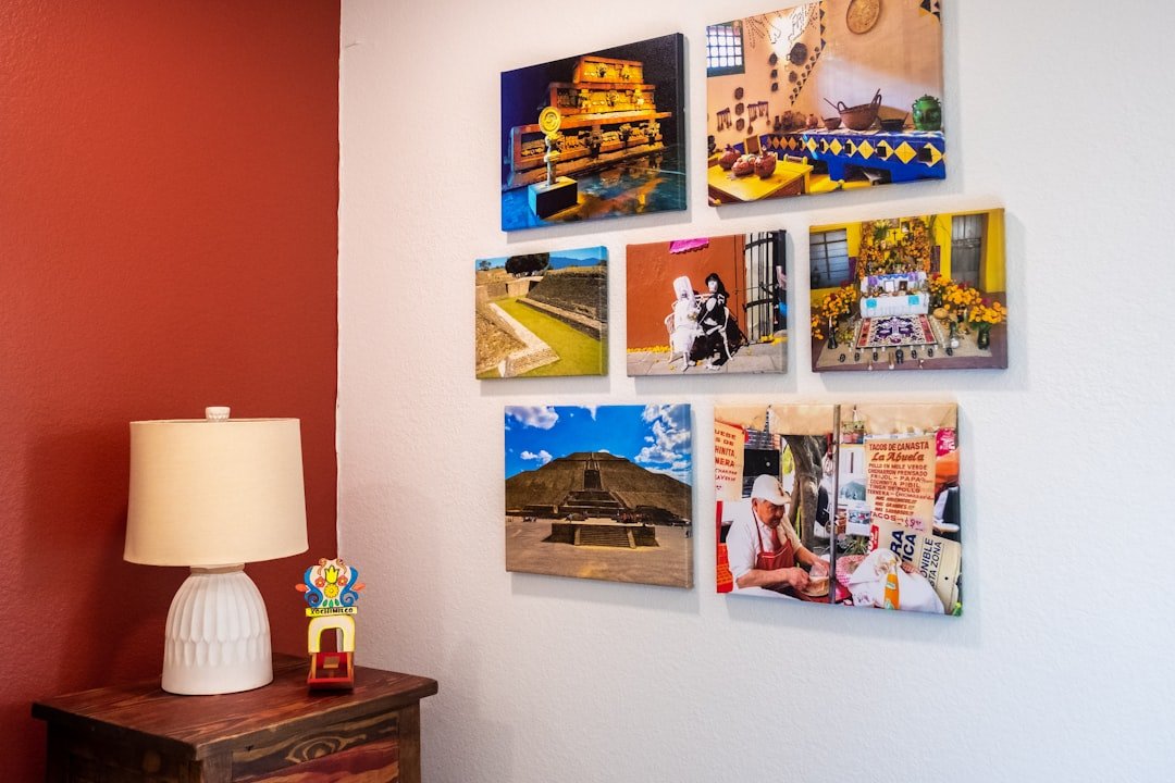 A stylish room with a captivating image wall showcasing diverse artwork. The corner table lamp casts a warm glow, adding a cozy ambiance to the space.