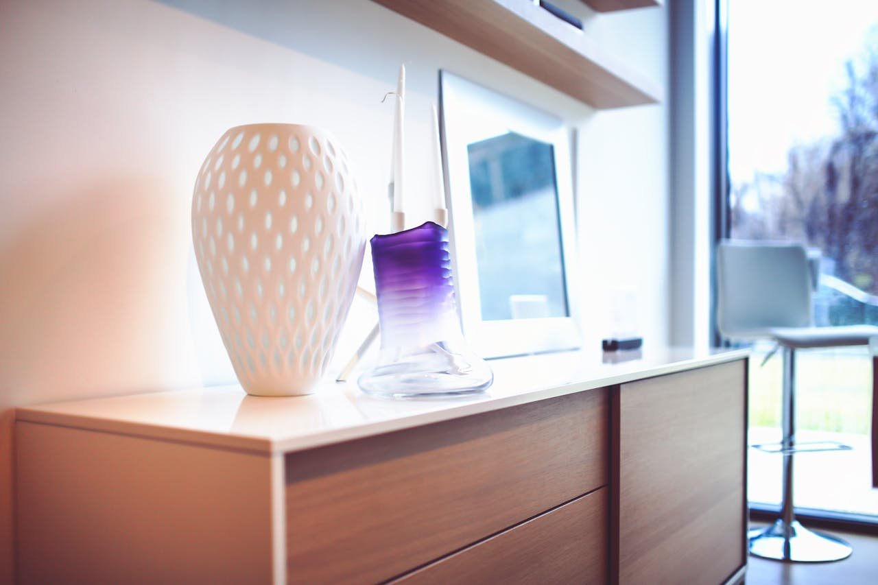 A stylish modern interior featuring decorative vases on a wooden sideboard, exuding contemporary design.