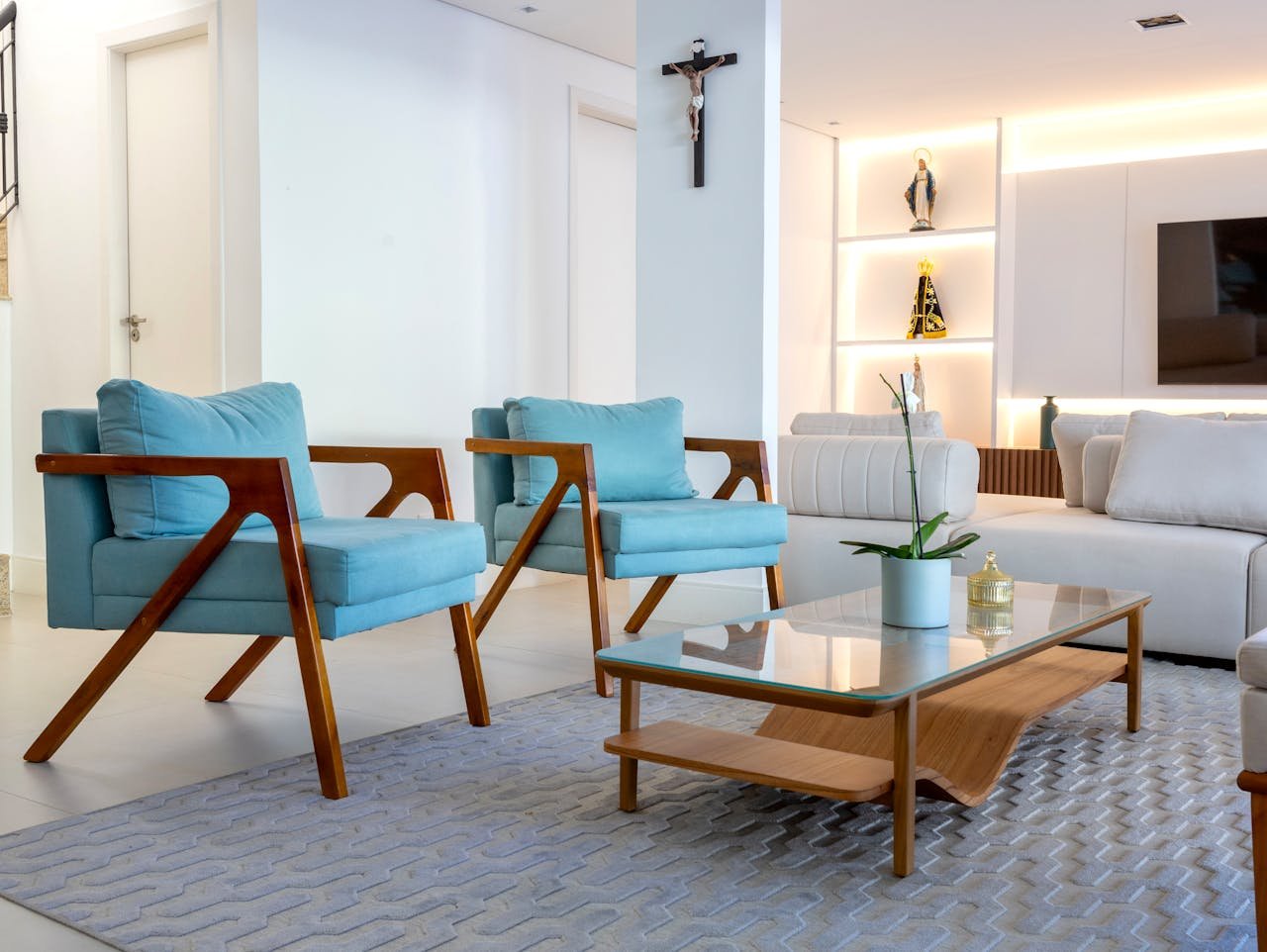 Stylish living room with contemporary blue armchairs, glass table, and decor elements in Salvador, Brazil.